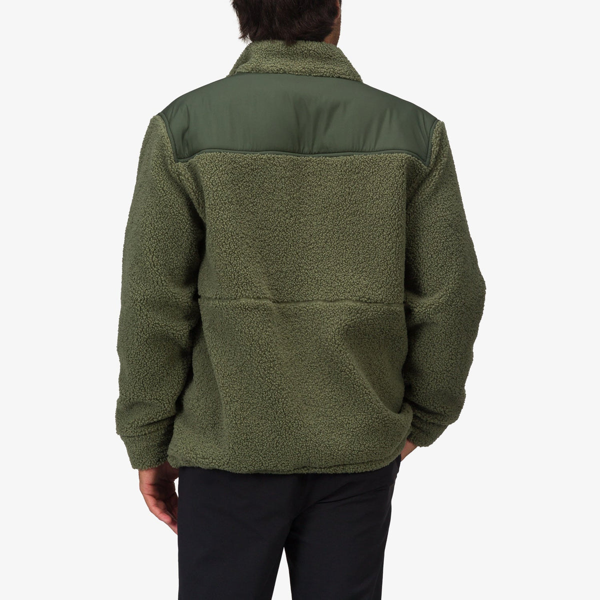 Back view of a man wearing an olive green Cooke Sherpa Jacket with a smooth shoulder panel, highlighting comfort and beach-inspired style.