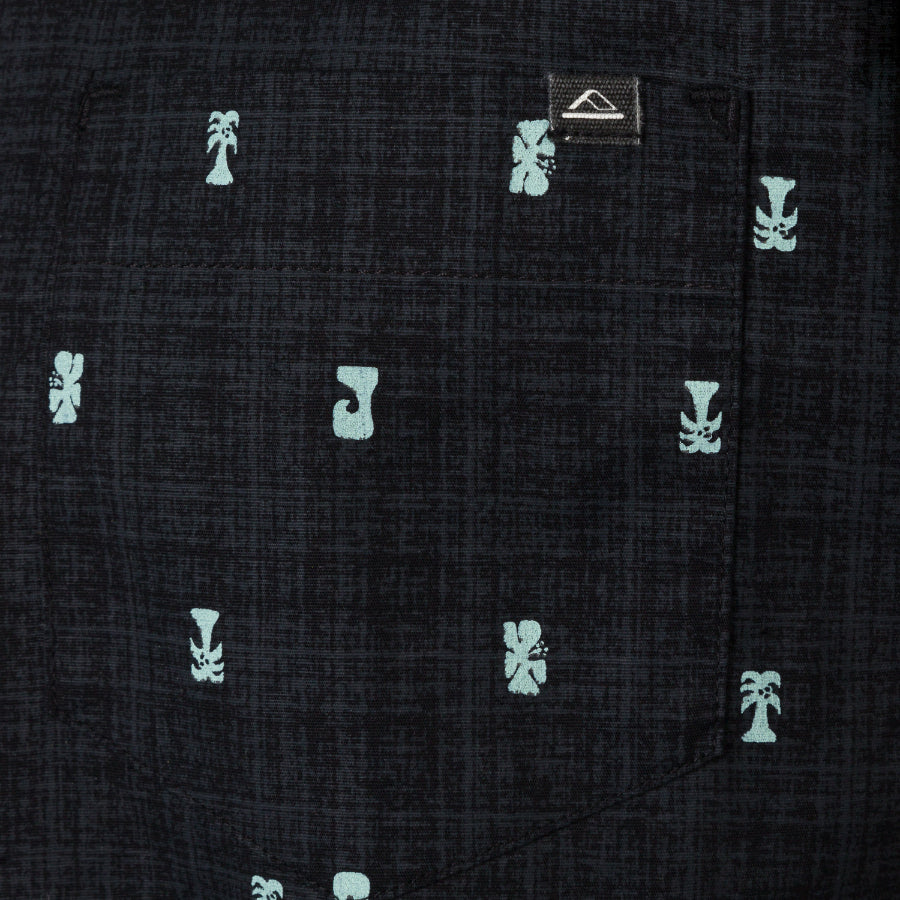 Close-up of Chaplin Classic Shirt black fabric pocket with light blue tropical and surf-inspired icons and small logo tag.