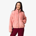 Woman wearing a pink Pilot Sherpa Jacket facing front with hands in pockets, showcasing comfort and cozy beach-inspired apparel.