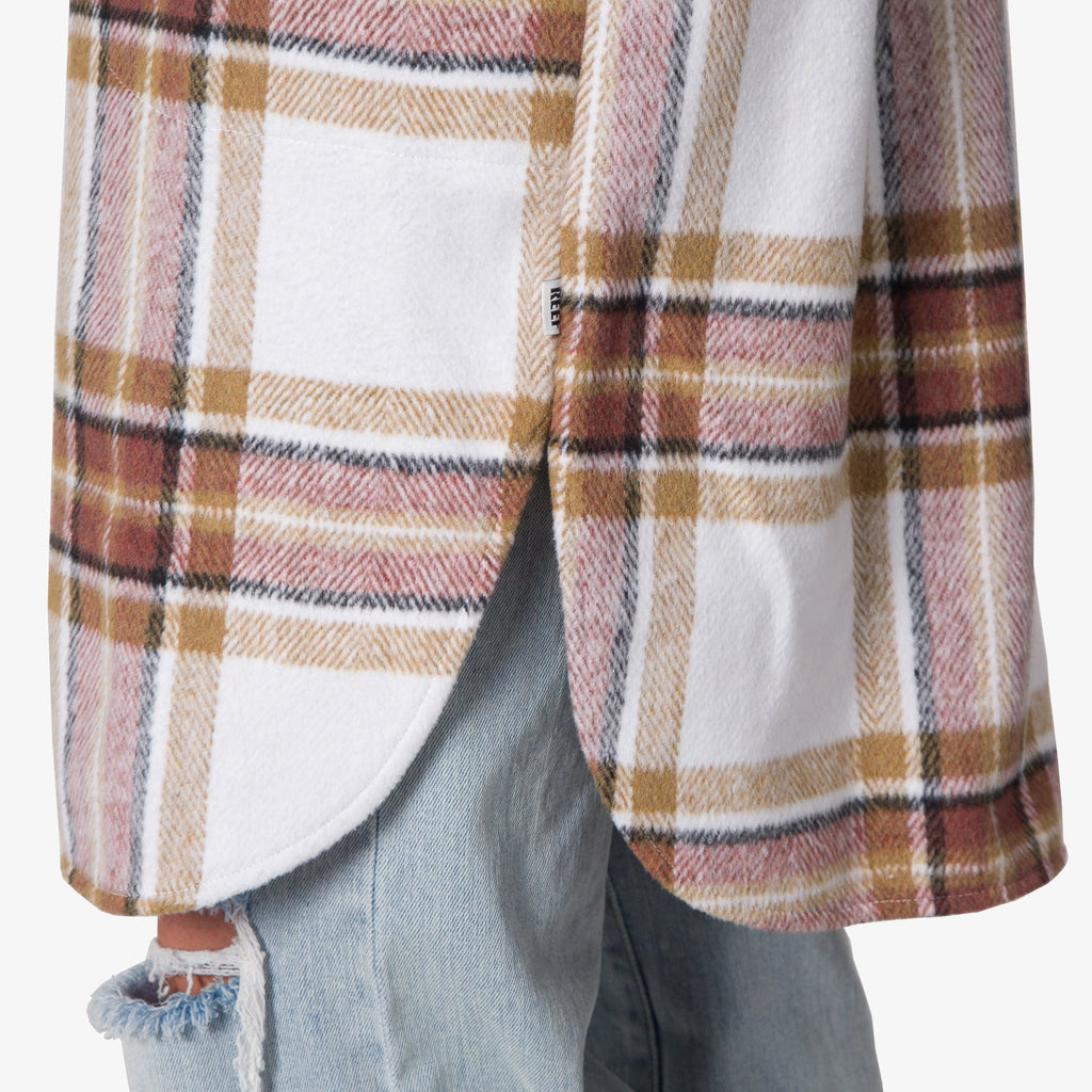 Victoria Shacket close-up of lower side hem with curved edge, plaid pattern in brown and white, comfort-focused beach apparel.