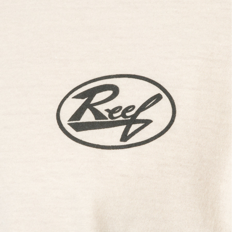 Close-up of cream-colored fabric with black Reef logo print on front of Auto Tee for men