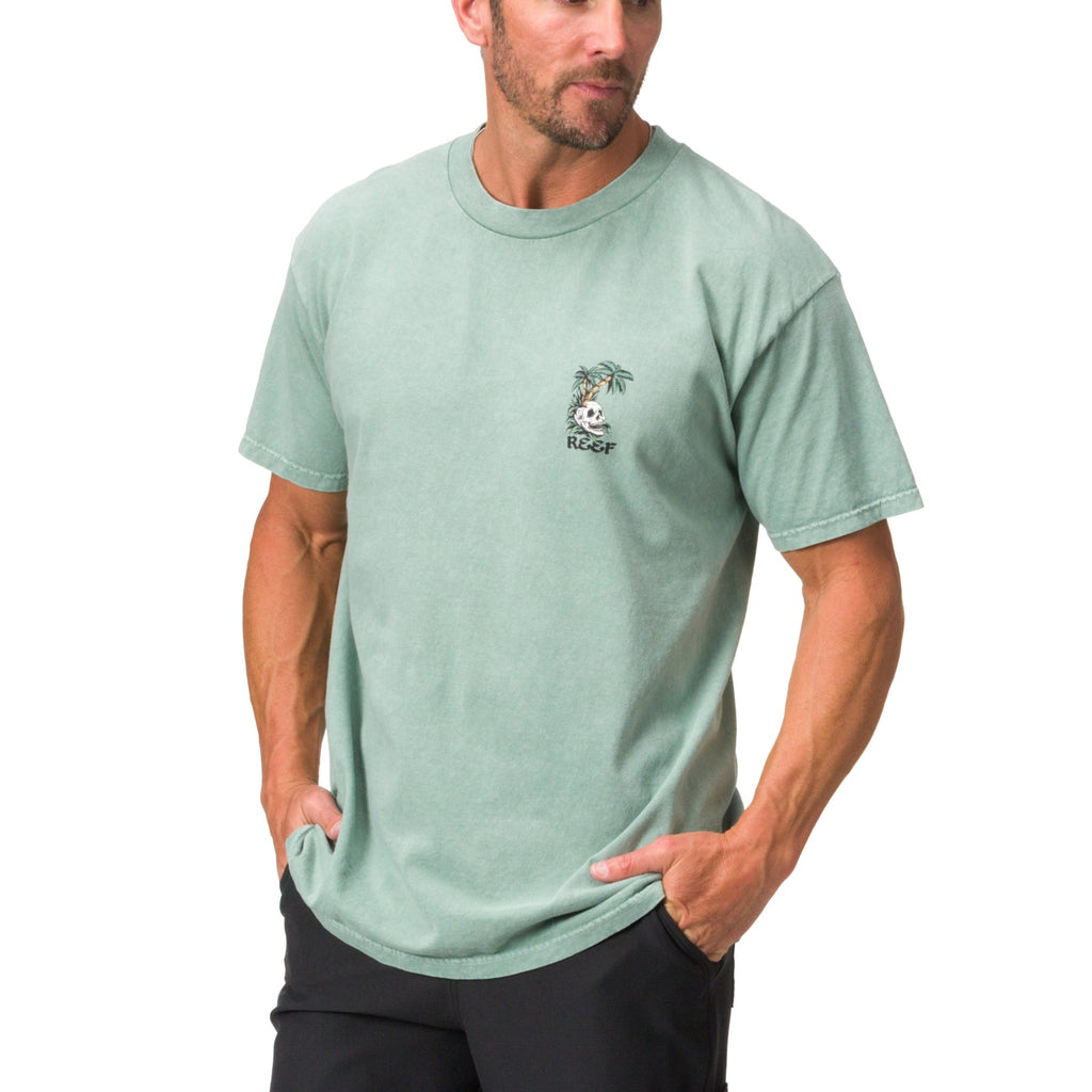 Man wearing light green Akin Tee facing slightly left, casual beach-inspired apparel with comfort-focused design.