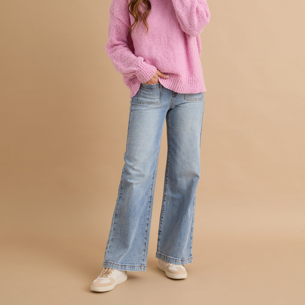 Woman wearing Boardwalk Callie shoes facing forward, shown in a full-body casual outfit with jeans and a pink sweater.