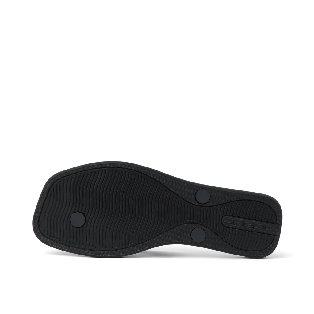 Solaye women's black sandal outsole facing up, showing textured water-friendly sole with REEF branding.