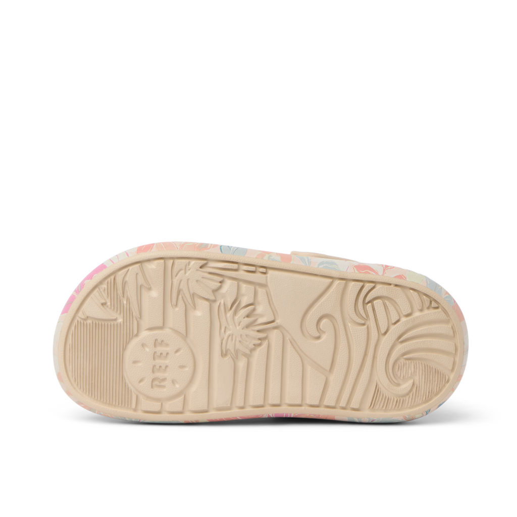 Little Rio Slide showing bottom sole facing up with embossed reef logo and surf-inspired patterns in apricot multi colors.
