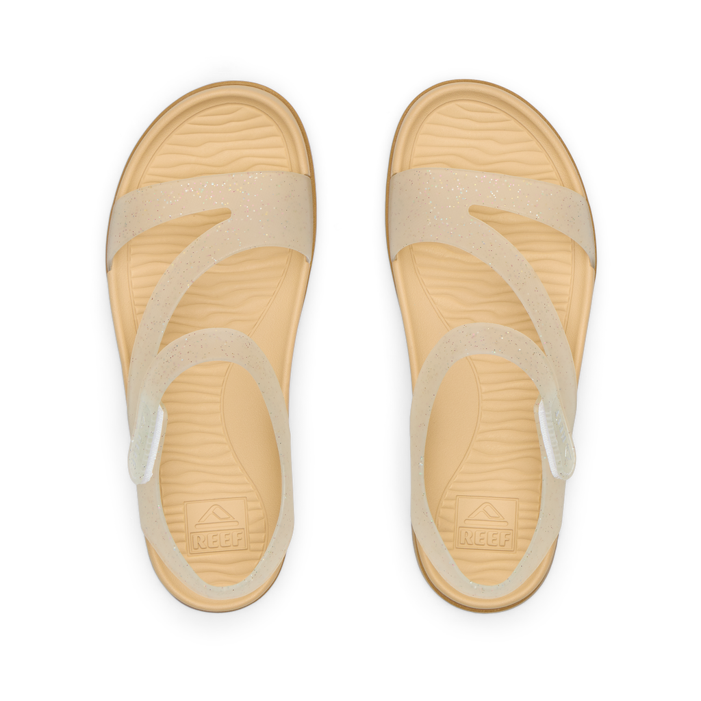 Top view of Kids Cali Coastin sandals for girls with glitter confetti straps and cushioned footbeds facing upward.