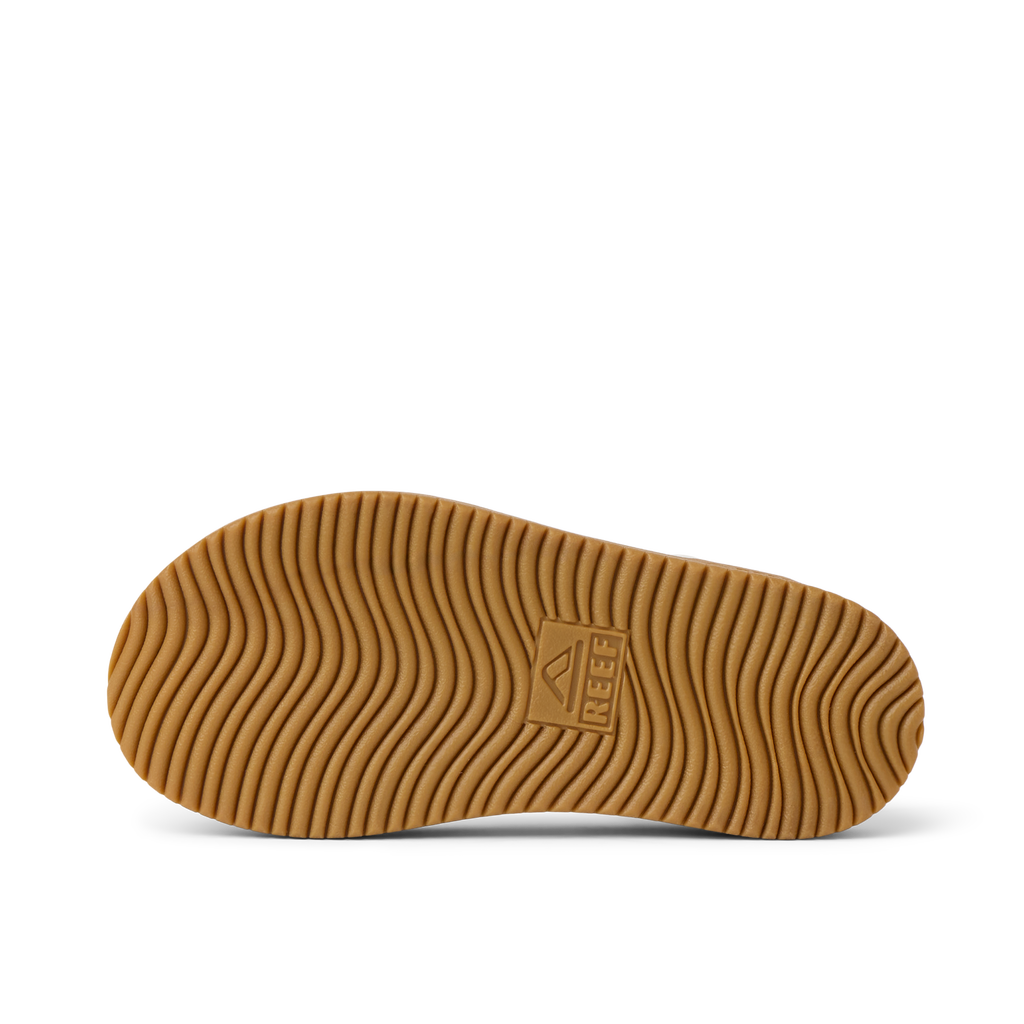 Little Cali Coastin left shoe sole facing up, showing wavy textured tread with REEF logo, designed for comfort and durability.