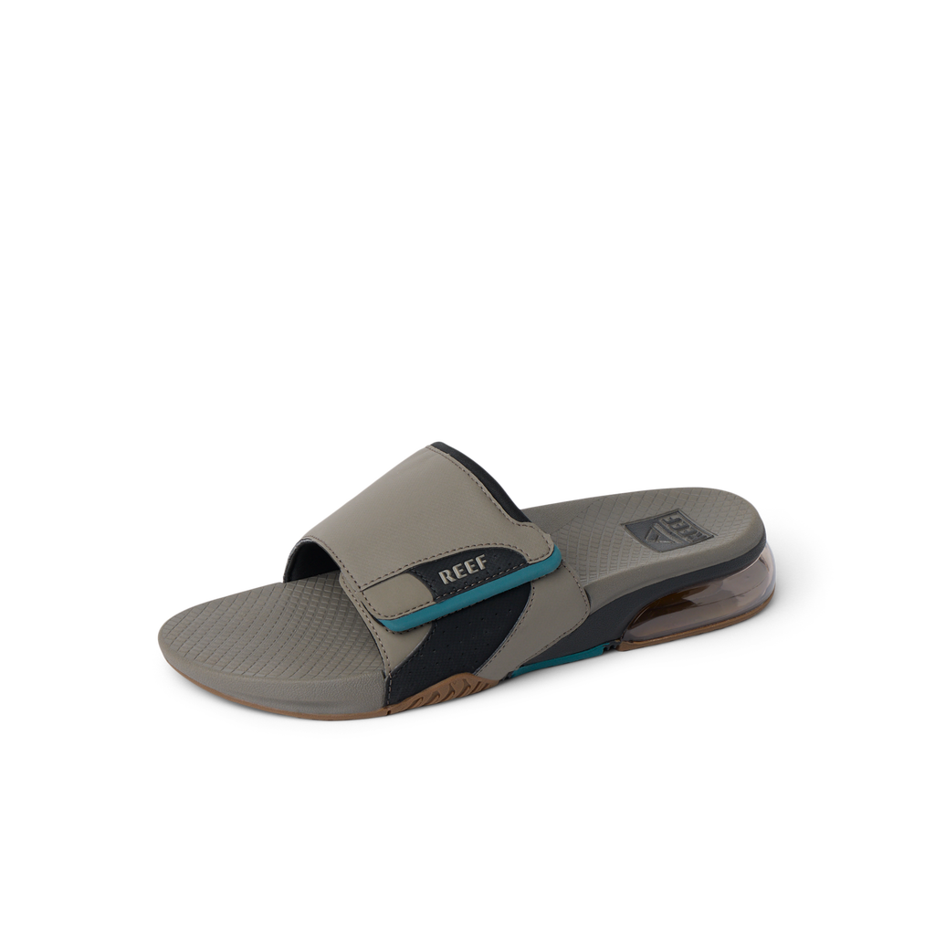 Fanning + Slide facing left, men's tan and spruce water-friendly slide with oversized airbag heel and cushioned footbed