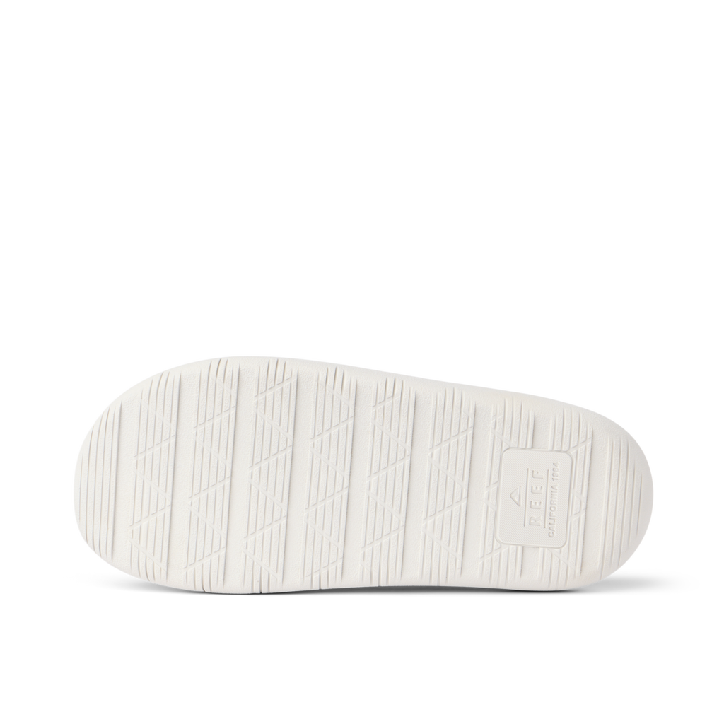 Rambler Kicker sandal sole facing up in off-white with textured grip and REEF logo for durable, lightweight beach comfort
