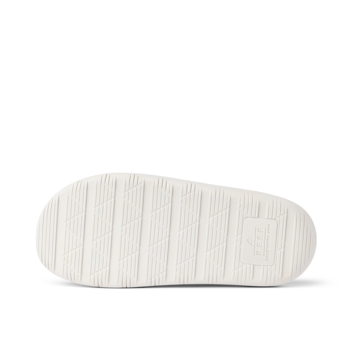 Rambler Kicker sandal sole facing up in off-white with textured grip and REEF logo for durable, lightweight beach comfort