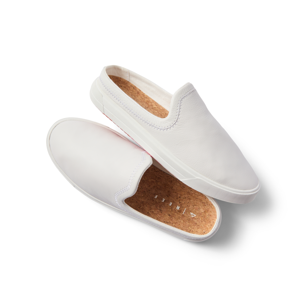 Coastal Breeze women’s white slip-on shoes facing right and top with comfort arch support and cork footbed close-up.