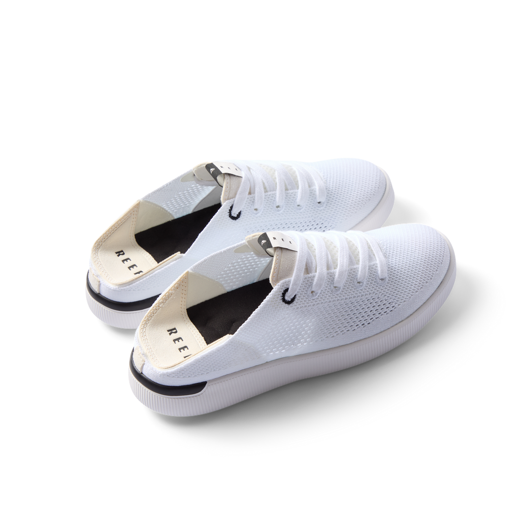 Reef Neptune women's white and black sneakers facing left, featuring breathable knit upper and cushioned sole for all-day comfort.