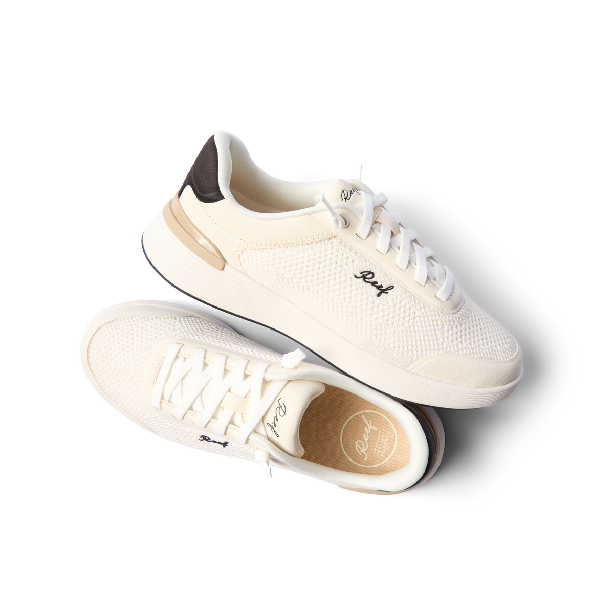 Pair of Shoreline Palisades sneakers in white and black, left shoe facing right, right shoe showing top close-up, surf-inspired comfort.