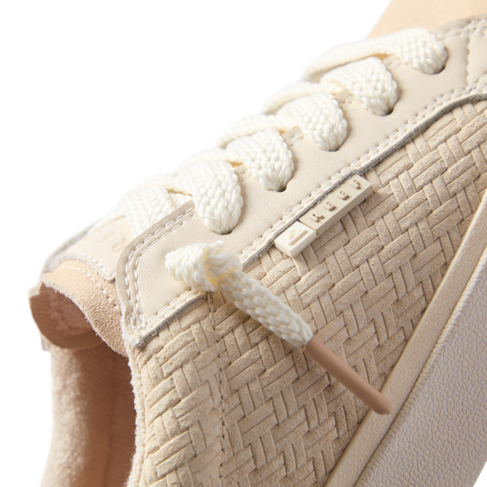 Close-up of the left side upper and laces of Lay Day Dawn sneaker in vintage sand with woven texture and soft cushioning.