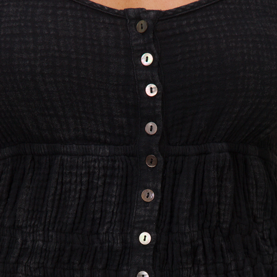 Close-up of the front button detail on the black Lainey Mini Dress from All Women's Apparel, designed for comfort and style.