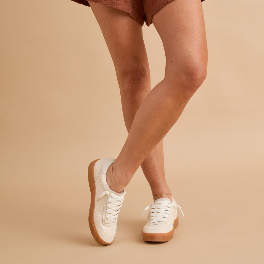 Lay Day Seas sneakers facing forward on woman’s feet, surf-inspired comfort with anatomical arch support and cushioning.
