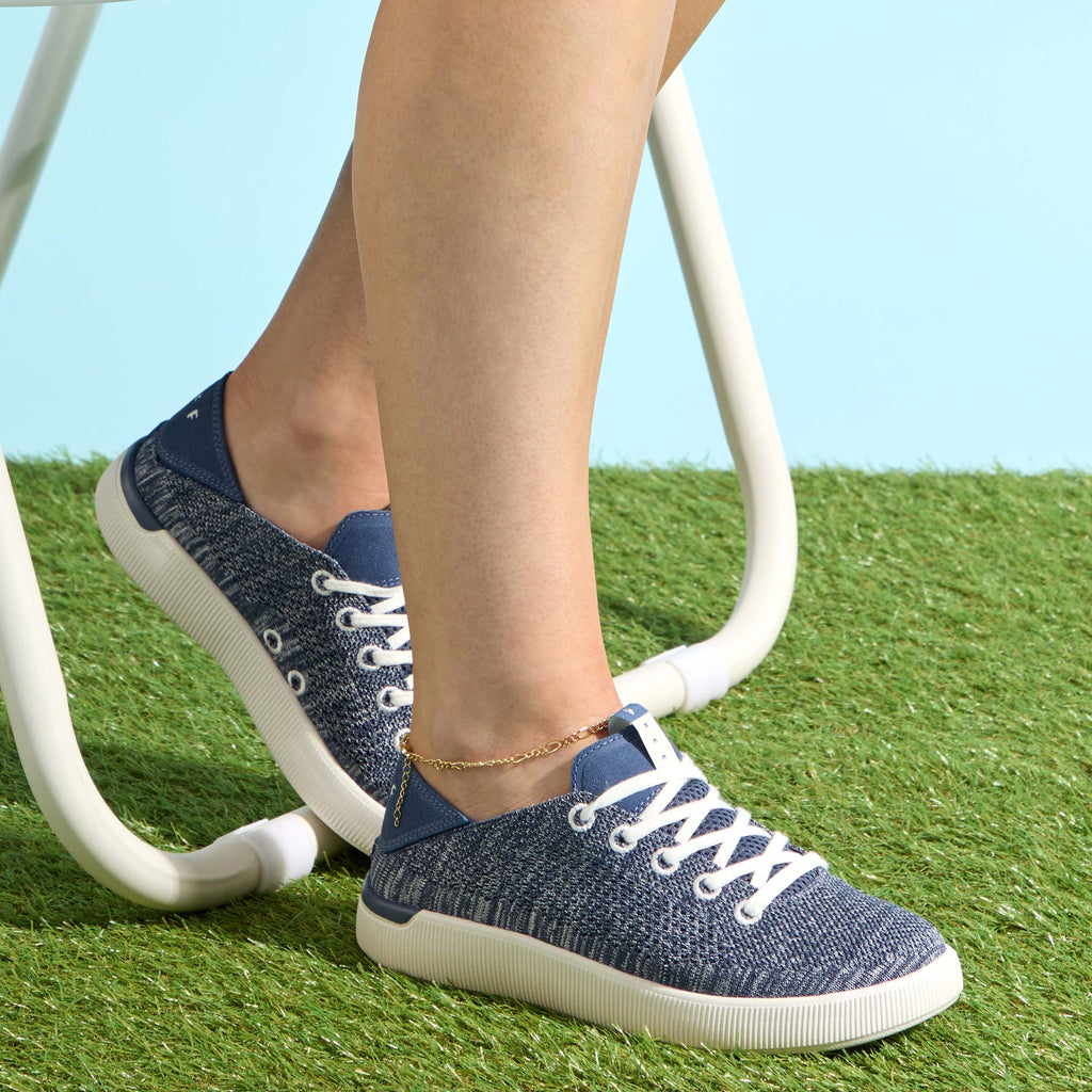 Reef Neptune sneakers facing right on grass, showing side and top, with soft cushioning and anatomical arch support.
