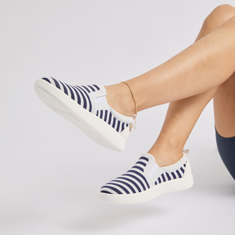 Neptune Elyse women's slip-on sneakers facing left, navy and white stripes, featuring cushioned, water-friendly comfort.