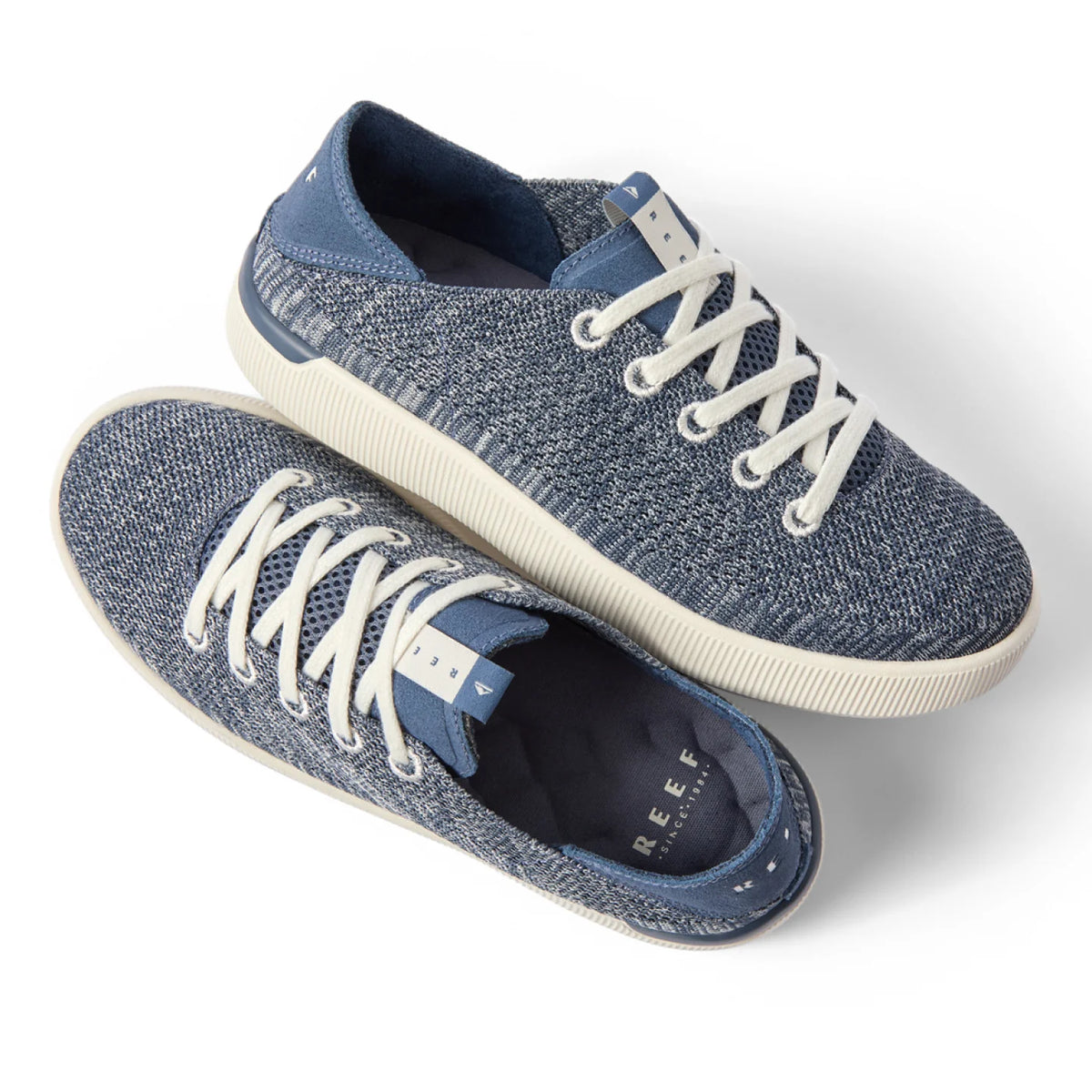 Pair of Reef Neptune women's sneakers shown from the top and right side in blue knit with white laces, designed for comfort and beach wear.