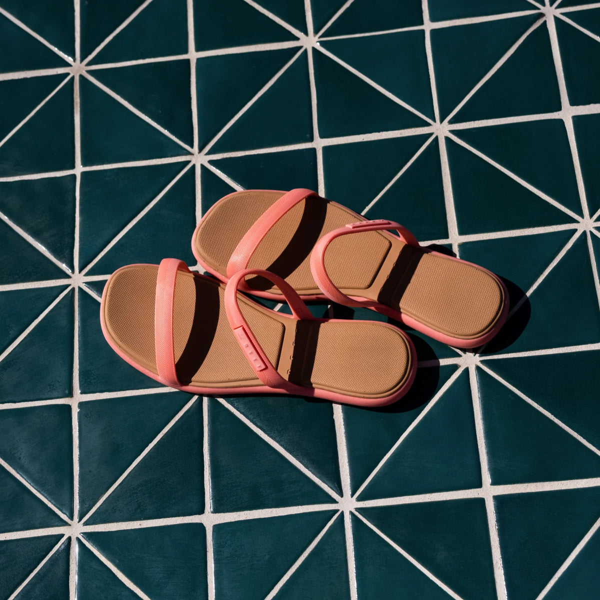 Water Willow Marina sandals facing upward with pink straps and molded footbeds on a geometric tiled surface