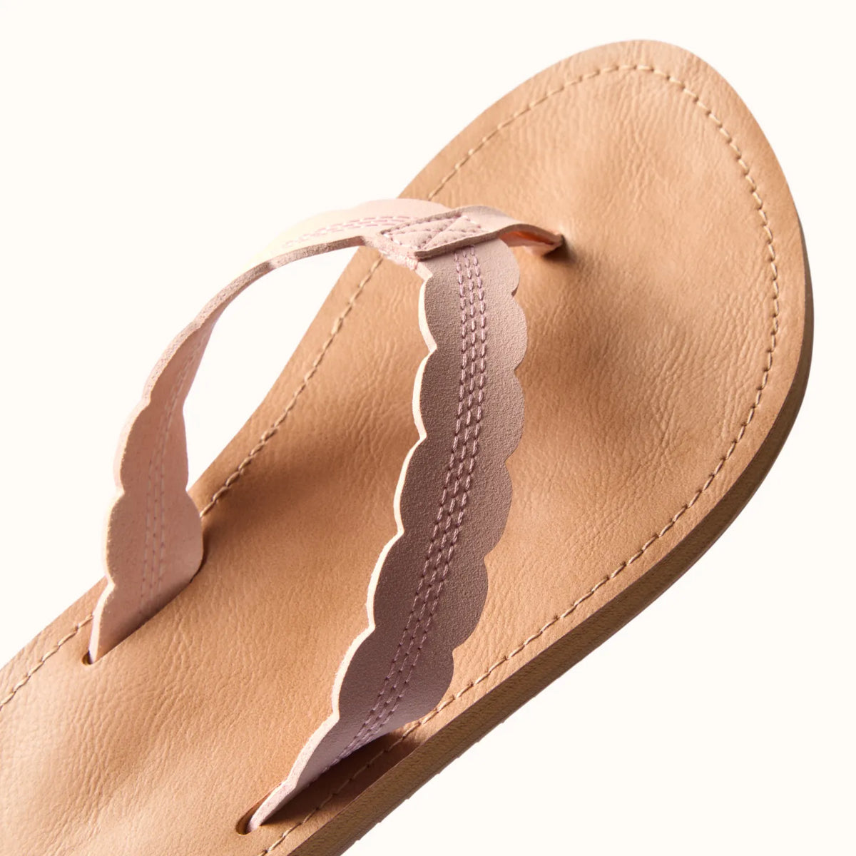 Reef Celine x Jenny sandal close-up of top straps in light peach, featuring scalloped edges and soft cushioning for beach comfort