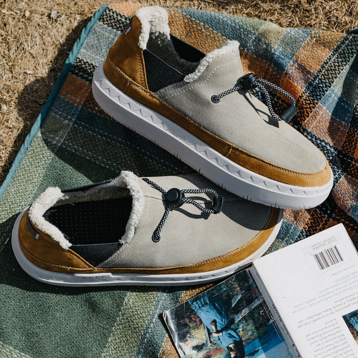 Rambler suede shoes facing right on a blanket, showing cozy terrycloth lining and cushioned white soles