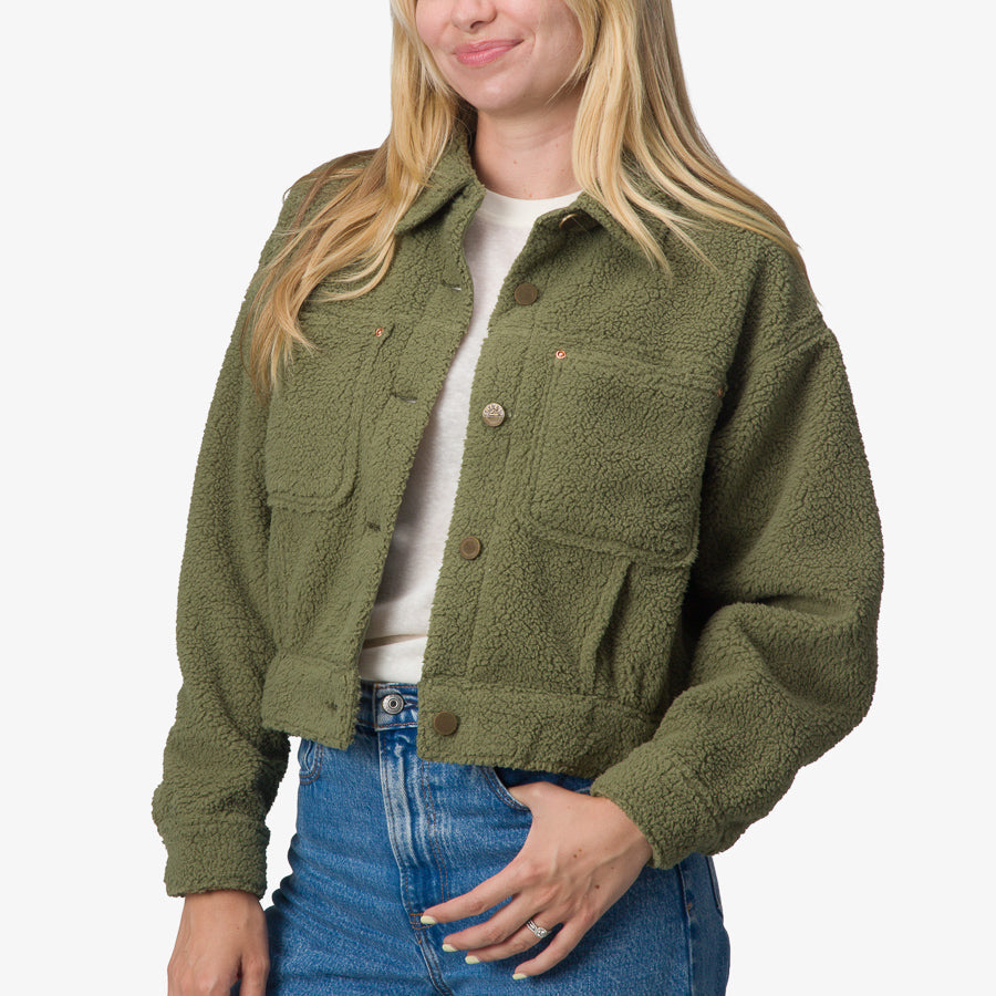 Woman wearing an olive Sammie Sherpa Jacket front view with textured comfort fabric and button closure designed for casual beachwear.