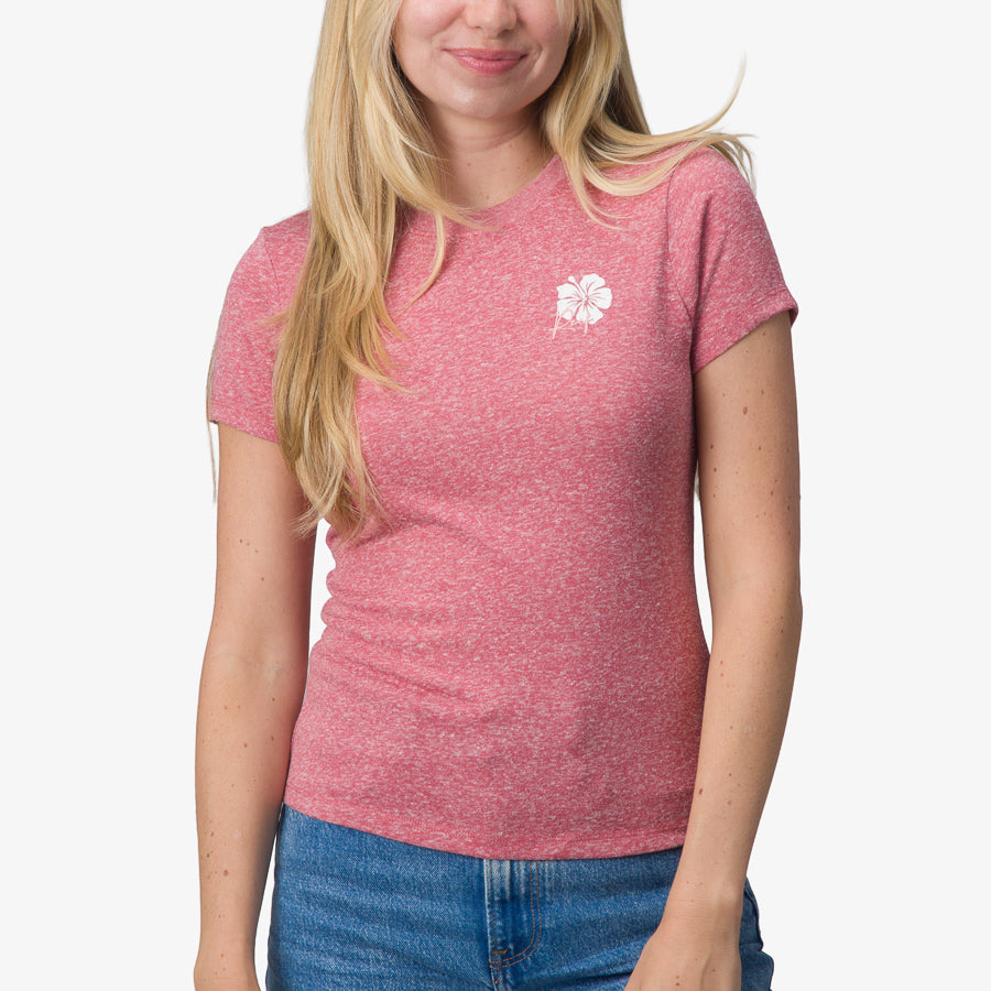 Woman wearing a mauve Saylor Fitted Tee with a small white hibiscus logo on chest, front view, beach-inspired comfort apparel.