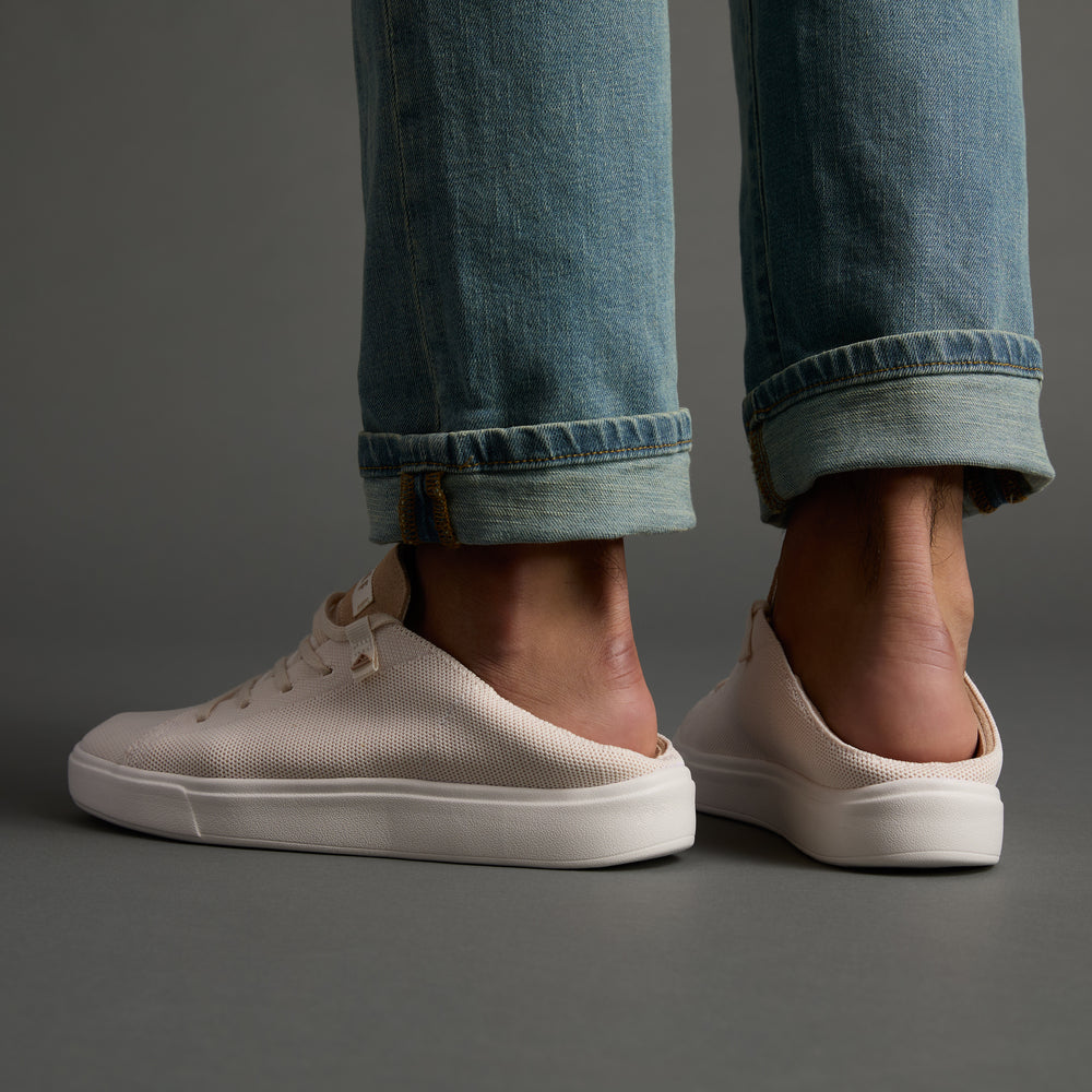 Terramar men's white knit sneakers facing sideways, showing heel and arch support with cuffed jeans, beach-inspired comfort