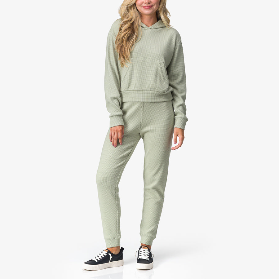 Woman wearing Tina Thermal Hoodie in desert sage, front view, highlighting soft, comfortable surf-inspired apparel.