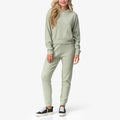 Woman wearing Tina Thermal Hoodie in desert sage, front view, highlighting soft, comfortable surf-inspired apparel.