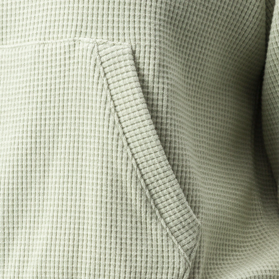 Close-up of the pocket on the Tina Thermal Hoodie in desert sage, showcasing textured, comfortable, breathable fabric.