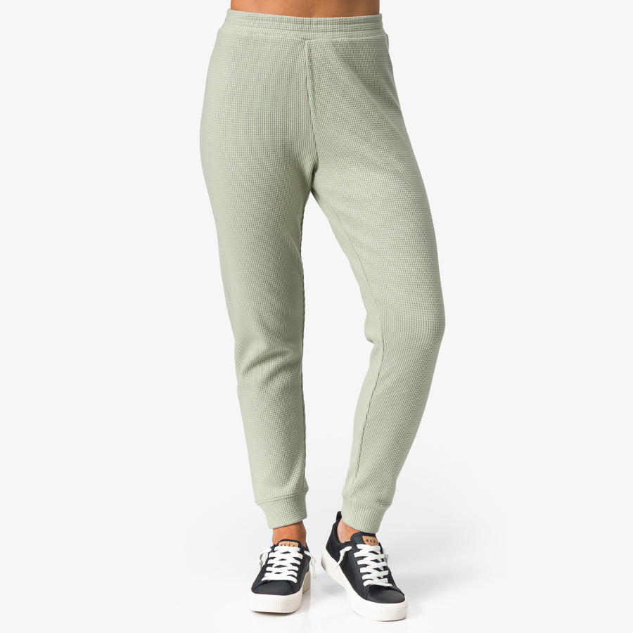 Front view of women's Tina Thermal Jogger in desert sage with sneakers, showcasing textured fabric and tapered ankle cuffs.
