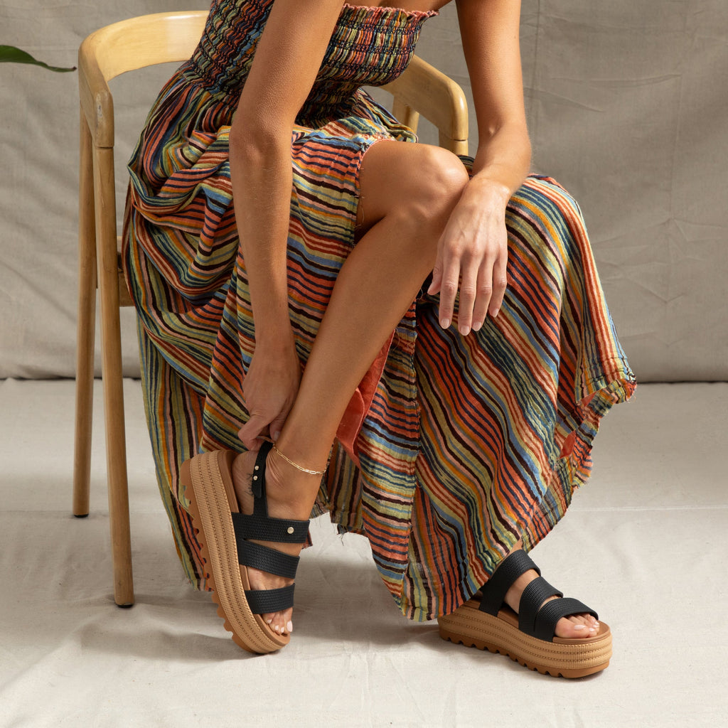 Woman wearing Water Vista Higher 2 sandals facing left, showing side and top with cushioned platform sole and black straps.