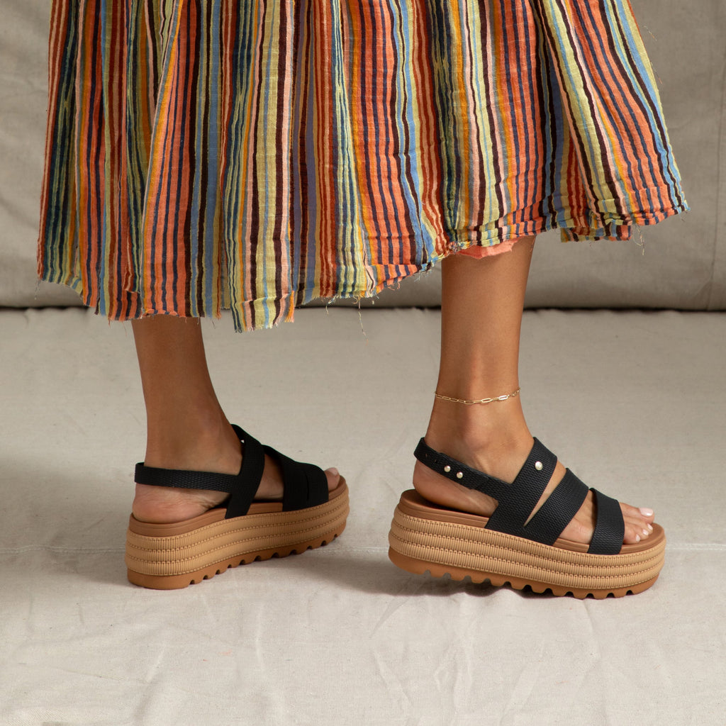 Pair of Water Vista Higher 2 sandals facing right, showing side view with black straps and tan platform sole, comfort focused design.